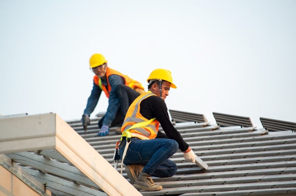 stock-photo-roof-repair-construction-worker-using-nail-gun-to-install-new-roof-on-top-roof-residential-building-1744176230-transformed-min