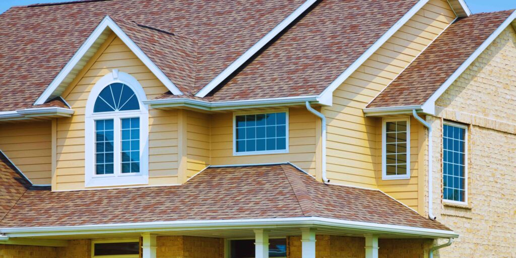 A house featuring a bright yellow roof complemented by elegant white trim.