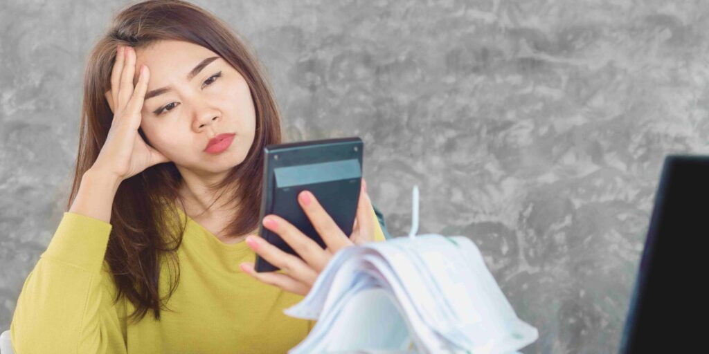 A woman sitting at her desk, focused on the calculator.
