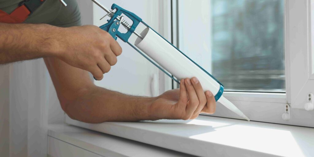 A man installs a window using a tool, demonstrating skilled craftsmanship and attention to detail in home improvement.